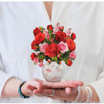 Small bouquet of red and pink roses in a floral ceramic vase