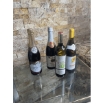 Four bottles of wine and sparkling juice on a glass table