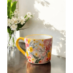 Floral-patterned mug with a yellow handle on a table