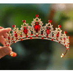 Hand holding a jeweled red and gold tiara
