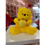 Yellow teddy bear holding a small plush fruit