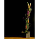 Tall floral arrangement with orange and purple blooms on a wooden base