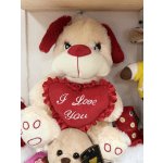 Plush dog holding a red heart that says "I Love You"