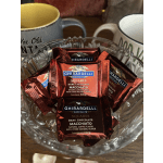 A glass bowl filled with wrapped Ghirardelli chocolate squares