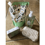 A soap refill pouch, liquid soap dispenser, soap bar box, and mesh sponge on a tiled floor.