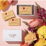 Cookies with "I love you mom" text beside colorful flowers and a gift box
