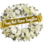 White floral funeral wreath with a gold memorial ribbon
