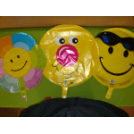 Three smiley-face balloons in bright colors, one with sunglasses