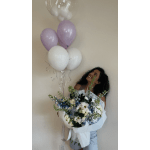 Woman holding a bouquet with pastel balloons overhead