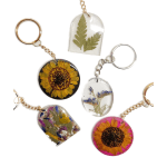 Pressed-flower resin keychains with sunflower and leaf designs