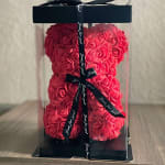 Heart-shaped box filled with red roses and tied with a black ribbon