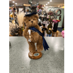 Plush teddy bear figurine on a wooden base with a graduation ribbon