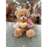 Plush teddy bear holding three heart pillows with Valentine messages