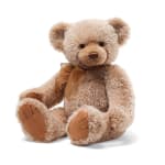 Plush teddy bear with a brown ribbon bow