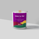 A coconut soy candle in a clear glass jar with a colorful label