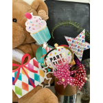 Teddy bear with colorful birthday party decorations and gift tags