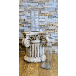 Two clear glass vases on a decorative pedestal and wood surface