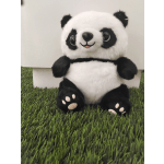 Plush panda bear sitting on artificial grass