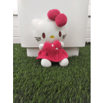Hello Kitty plush holding a pink heart, seated in front of a white box