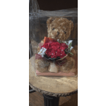 Teddy bear holding a red flower bouquet in a clear gift box