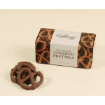 Box of milk chocolate covered pretzels with several loose pretzels in front on a light background