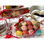 Gift boxes of decorated macarons with red ribbons and heart decorations
