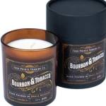 Two bourbon and tobacco scented candles in glass jars with black lids