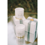 Three white candles and two white gift boxes with green ribbon