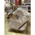 Decorated white cookie in a clear gift box with gold ribbon