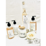 Soap bottles and a candle with a white rose