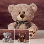 Plush teddy bear with a ribbon bow, shown in beige, gray, and brown variants.
