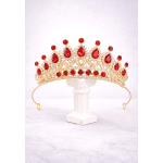 Gold tiara with red gemstones on a white stand