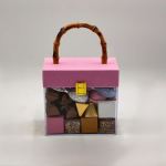 Pink gift box with assorted chocolates and a bamboo handle
