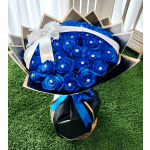 Bouquet of bright blue roses wrapped in black paper with a white ribbon