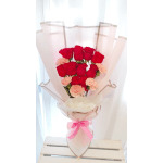 Bouquet of red roses and pale pink carnations wrapped in blush paper