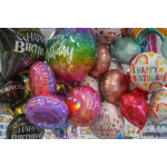 Cluster of colorful birthday balloons with printed messages