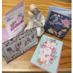 Mother's Day cards and a ceramic mother-and-child figurine on a wooden table