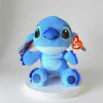 Blue plush Stitch toy sitting on a white pedestal