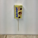 Butterfinger candy bar wrapper on a wooden stick