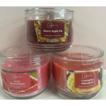 Set of three scented glass jar candles stacked in a small pyramid on a light background.