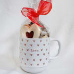 Heart-shaped cookies in a white mug with a red ribbon