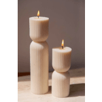 Two lit cream pillar candles with ribbed sides