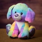 Rainbow plush dog toy with glittery paws sitting on a brown surface