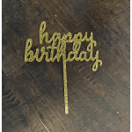 Gold glitter "happy birthday" cake topper on a dark surface