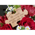 Red roses and white daisies around a wooden puzzle sign
