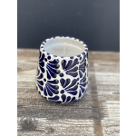 Patterned ceramic candle holder with a white candle inside