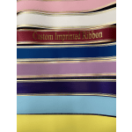 Stacked rolls of custom printed ribbon in pink, white, red, blue, purple, light blue, and yellow