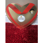 Heart-shaped Ferrero Rocher chocolate box on a red textured surface