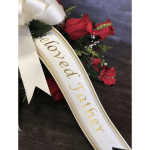 Red floral spray with a white ribbon reading "Beloved Father"