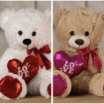 Two teddy bears holding heart pillows with "LOVE" text
